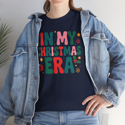 Person wearing a navy blue t-shirt with colorful text 'IN MY CHRISTMAS ERA' and a denim jacket.